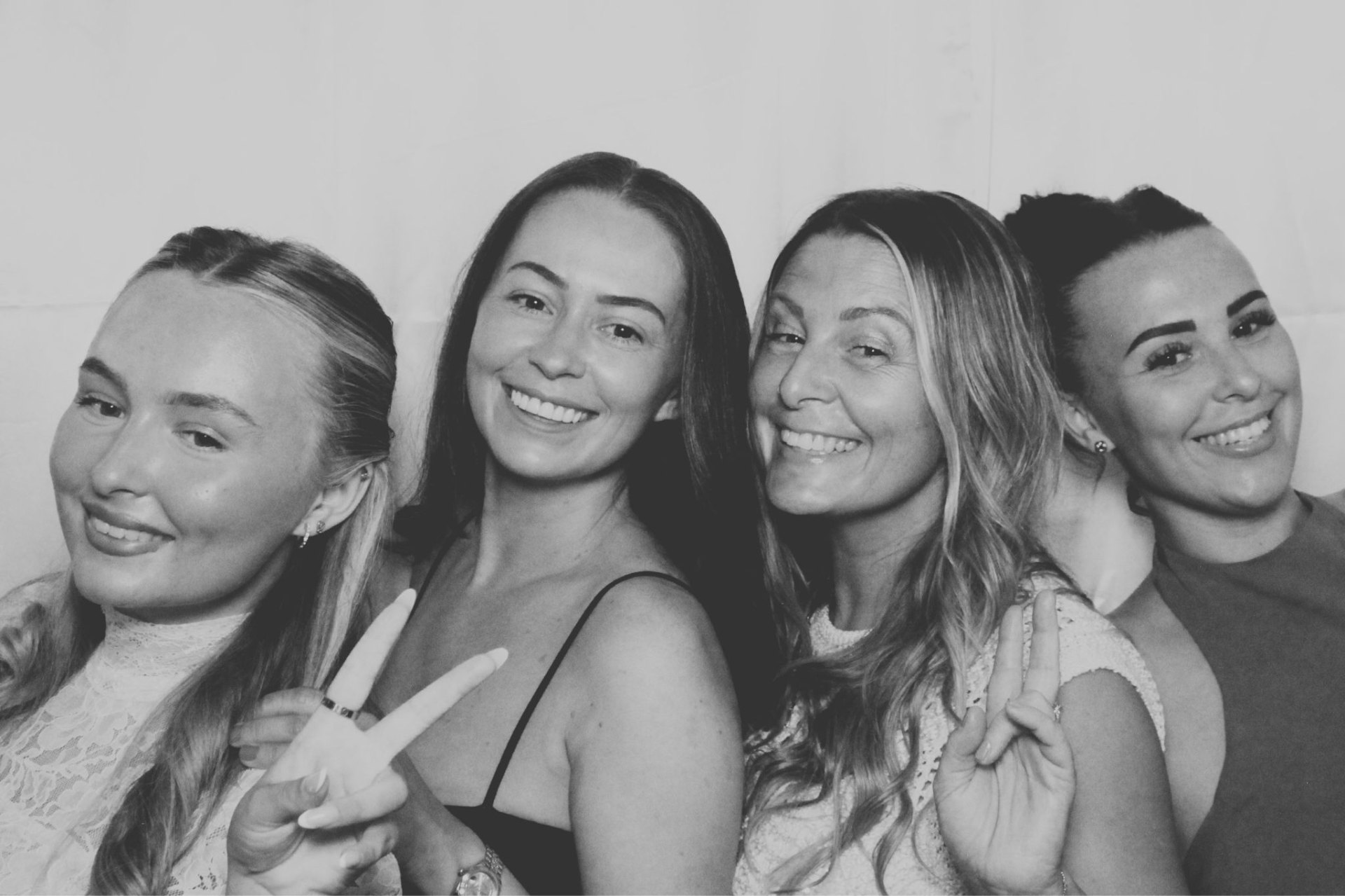 Four friends posing together in the photo booth